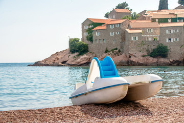 White catamaran on the beach of Sveti Stefan in Montenegro 