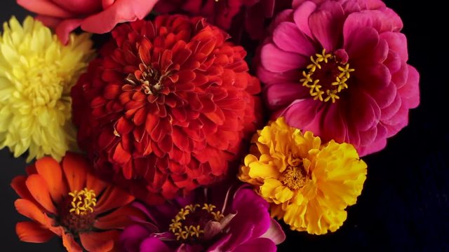 A bouquet of flowers spinning on a black background. Close up.
