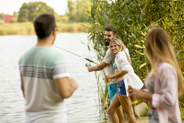Fototapeta premium Young people enjoy fishing on river