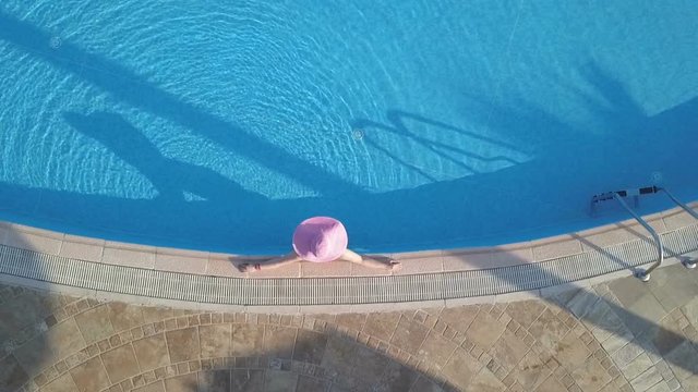 Young woman relaxing at swimming pool. Aerial footage
