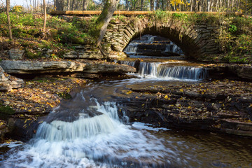 Old arch bridge with waterfall in the landscape