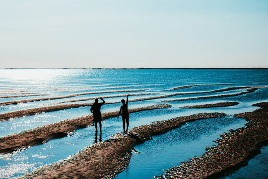 Summer vacation in the Netherlands - Silhouettes waving at the bottom of the Dutch Wadden Sea