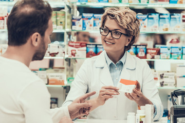 Portrait of Woman Pharmacist Counseling Customer