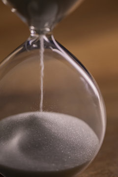 Hourglass on a wooden table macro