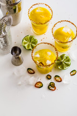 cocktail margarita of tequila, mango juice, hot pepper and lime on the table. bar accessories