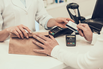 Fototapeta na wymiar Closeup Customer Pays with Credit Card in Pharmacy