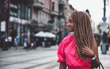 Beautiful smiling African girl walking in the city street