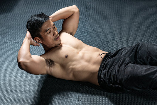 Muscular builder man sit-ups at gym.concept sport man in fitness centrer