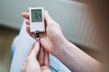 Woman Measuring Blood Sugar with a Glucose Meter