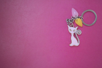 keychain with a pink cat on a red background, copy space, a place for advertising