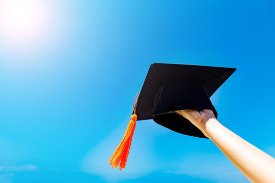 Graduate celebrating put graduation cap up to the sky,Education Success in summer Concept