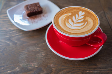Close up of a cup of coffee and cake.