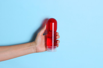  an intimate lubricant in a female hand on a color background. comfortable sex. intimate gel.