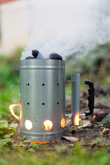 Firing up charcoal before barbecue in Charcoal Chimney Starter