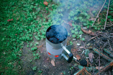 Firing up charcoal before barbecue in Charcoal Chimney Starter