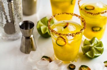 cocktail margarita of tequila, mango juice, hot pepper and lime on the table. bar accessories