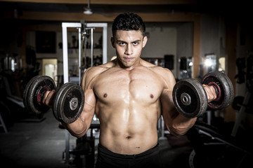 Plakat Young man exercising in dark and old gym