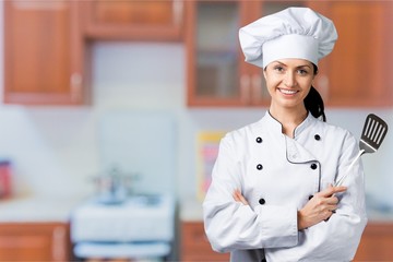 Portrait of young woman chef on background