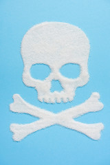 The skull made of sugar on blue blue background. Diabetes concept. Sugar Kills. Suggesting dieting concept. Copy space