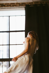 Fototapeta premium Dancer girl moving and looking at the window wistfully