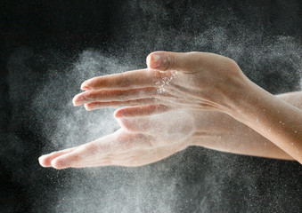 Fototapeta na wymiar hands with flour on a black background