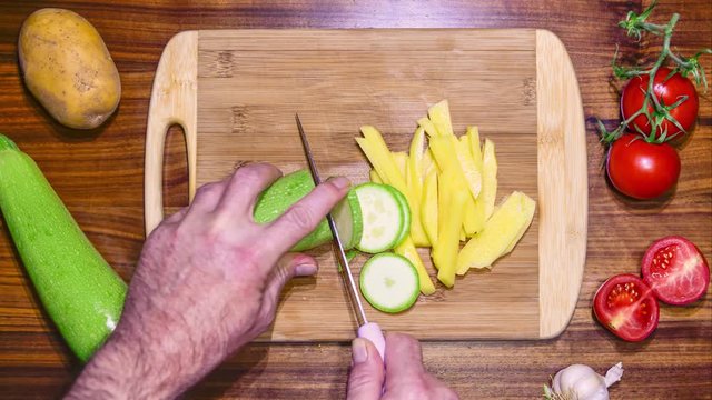 Cutting zucchini and potato on a chopping board. Timelapse POV.