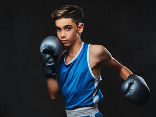 Plakat Handsome young boxer during boxing exercises, focused on process. Isolated on the dark background.