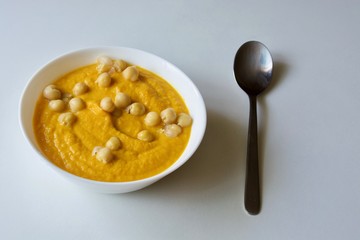 Tasty carrot-chickpea soup in the white bowl.