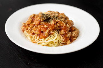 Spaghetti on black wooden background