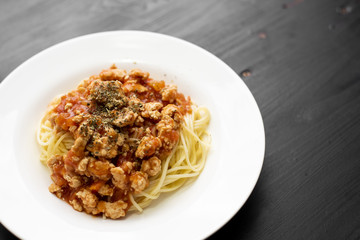 Spaghetti on black wooden background