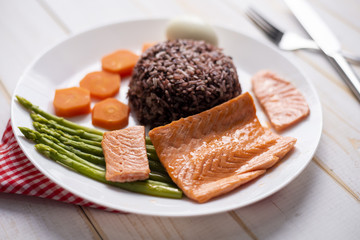 Health food concept, salmon with rice and vegetable on wood background