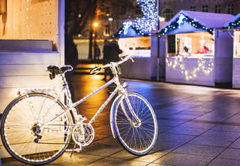 Traditional Christmas market in Europe. Vintage bike with lights decoration on a Christmas fair.