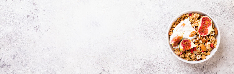 Muesli with Nuts Yogurt and fresh Figs on the gray Background.Granola Healthy Breakfast. Sweet food Dessert. Snack  Dry Diet Nutrition Concept.Top View. Flat Lay.Copy space for Text.Banner