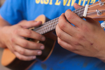 the musician plays on the ukulele
