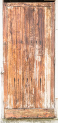 old wooden door with yellow paint peeling off.
