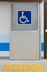 Aluminium door with sign for disabled people with Tactile paving