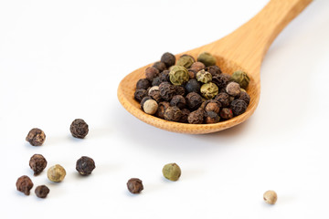 Different peppercorn in a wooden spoon.