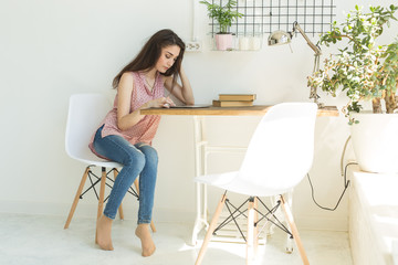Technology and people concept - Young beautiful woman sitting at the white table with tablet