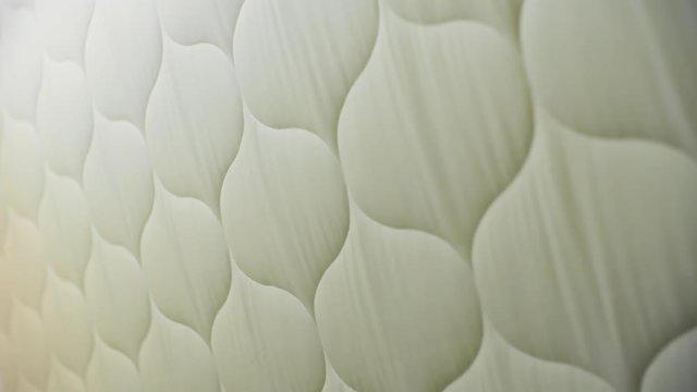 Close-up view of quilted white cotton fabric during process of manufacturing in textile factory