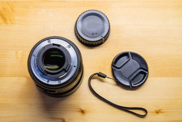 Photo DSLR Camera or Video lens close-up on wooden background, objective, concept of photographer camera man job, looking for a photographer, journalist, a videographer to work