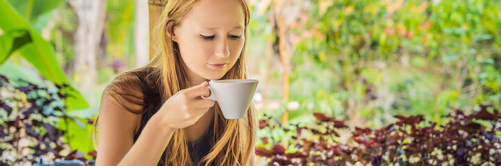 Young woman drinks coffee Luwak in the gazebo BANNER, long format