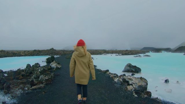 Happy and excited young female traveller explores far away exotic destination, walks around hot springs in iceland, incredible travel blogger lifestyle vibe, wanderlust freedom emotions and experience