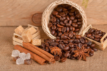 Coffee beans and cinnamon on a background of burlap. Roasted coffee beans background close up....