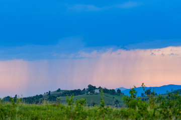 Rural landscape with rain storm over the meadow