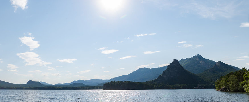 Panorama, beautiful mountains covered with pine forest on the lake.