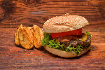 Hamburgers and French fries on the wooden tray.