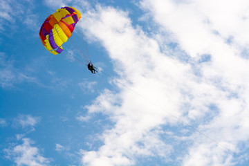 Man flying on a round bright parashute