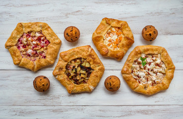 Pattern of different handmade pies on a white wooden table.
