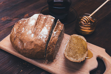 Sandwich of rye bread with honey and cup of black tea