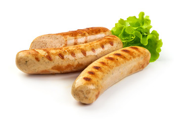 Grilled Munich sausages with green lettuce, isolated on white background.